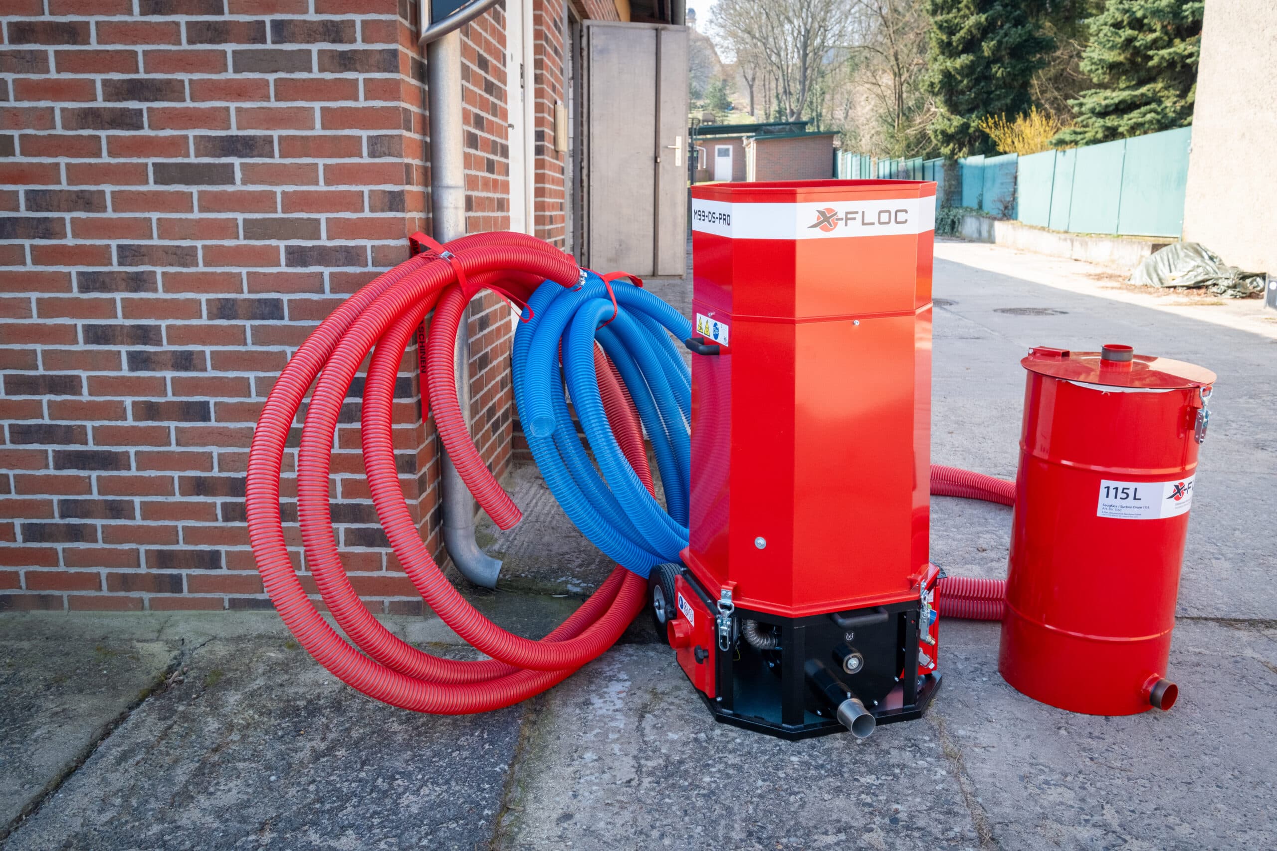 Einblasmaschine im Einsatz vor einer Klinkerfassade — Porobead-Granulat wird in die Hohlschicht eingebracht
