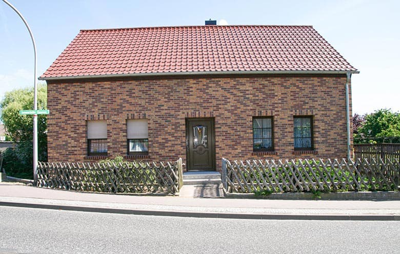 Einfamilienhaus mit rot gemischter Klinkerfassade, Straßenansicht nach der Sanierung